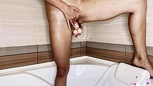 Rjavolaska uporablja dildo, da doseže orgazem v kopalnici