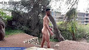 Ein muskulöser Mann zeigt seine Fitness, indem er nackt in der freien Natur hockt